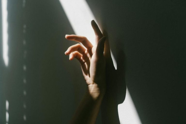 The Healing Power of Orgasm: Reclaiming the Body, Nervous System, and Feminine Wisdom in Mid-Life Female hand on a wall in shadow and light